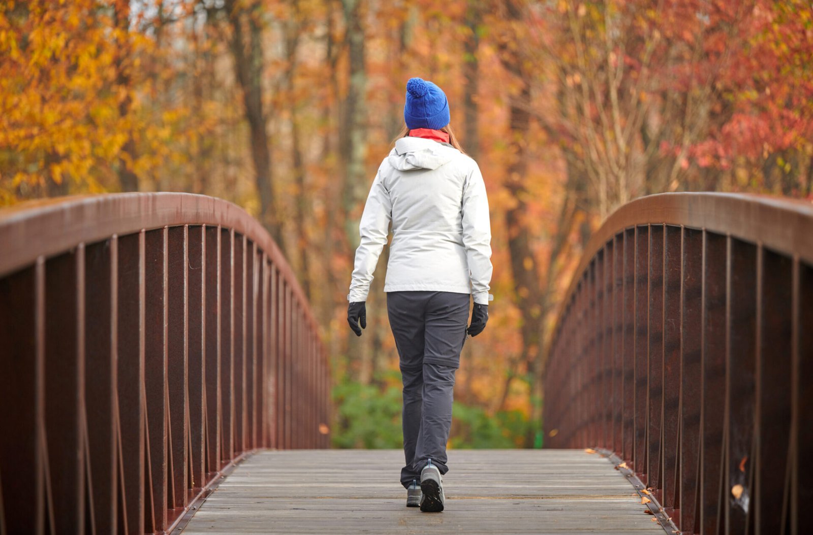 Woman hiking at Stowe Recreation Path on autumn day in Vermont, USA.